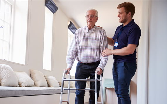 Medarbejder hjælper borger på plejehjem