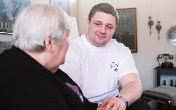 Pædagogisk vagt fra TrygtMiljø hjælper ældre kvinde med demens