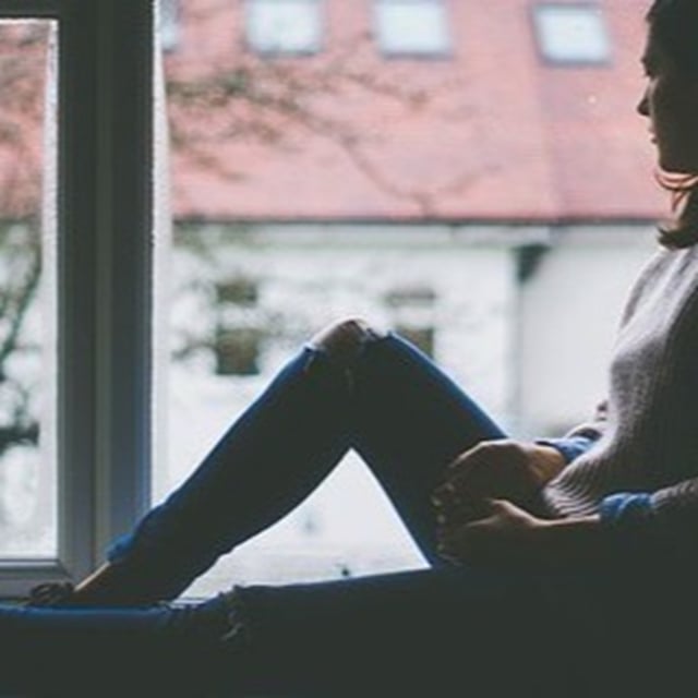Ensom person fra psykiatrien kigger ud ad vinduet